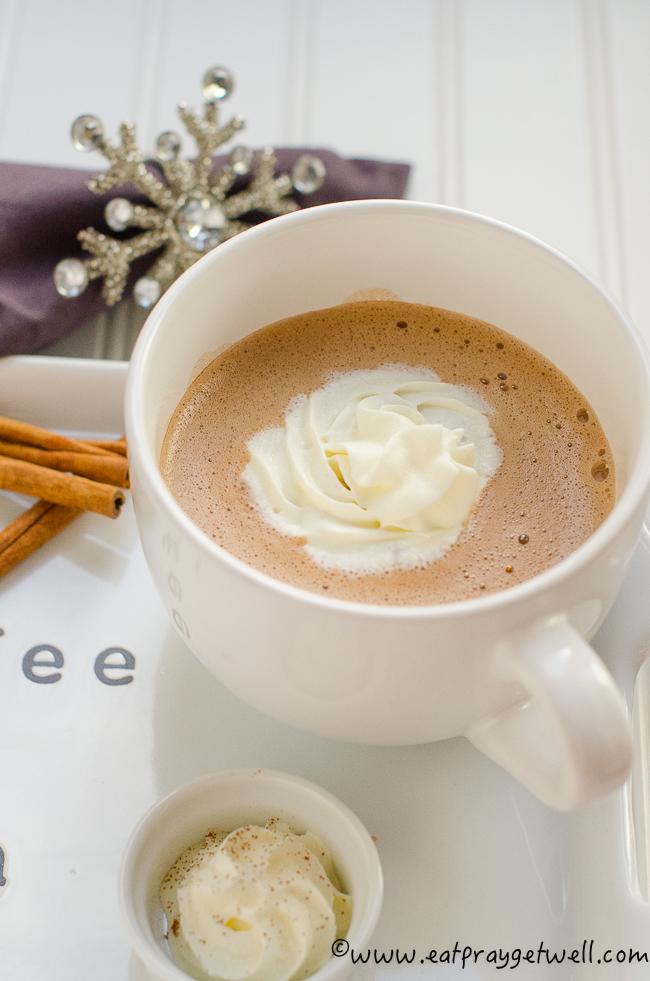hot chocolate in white mug with whipped cream on the side