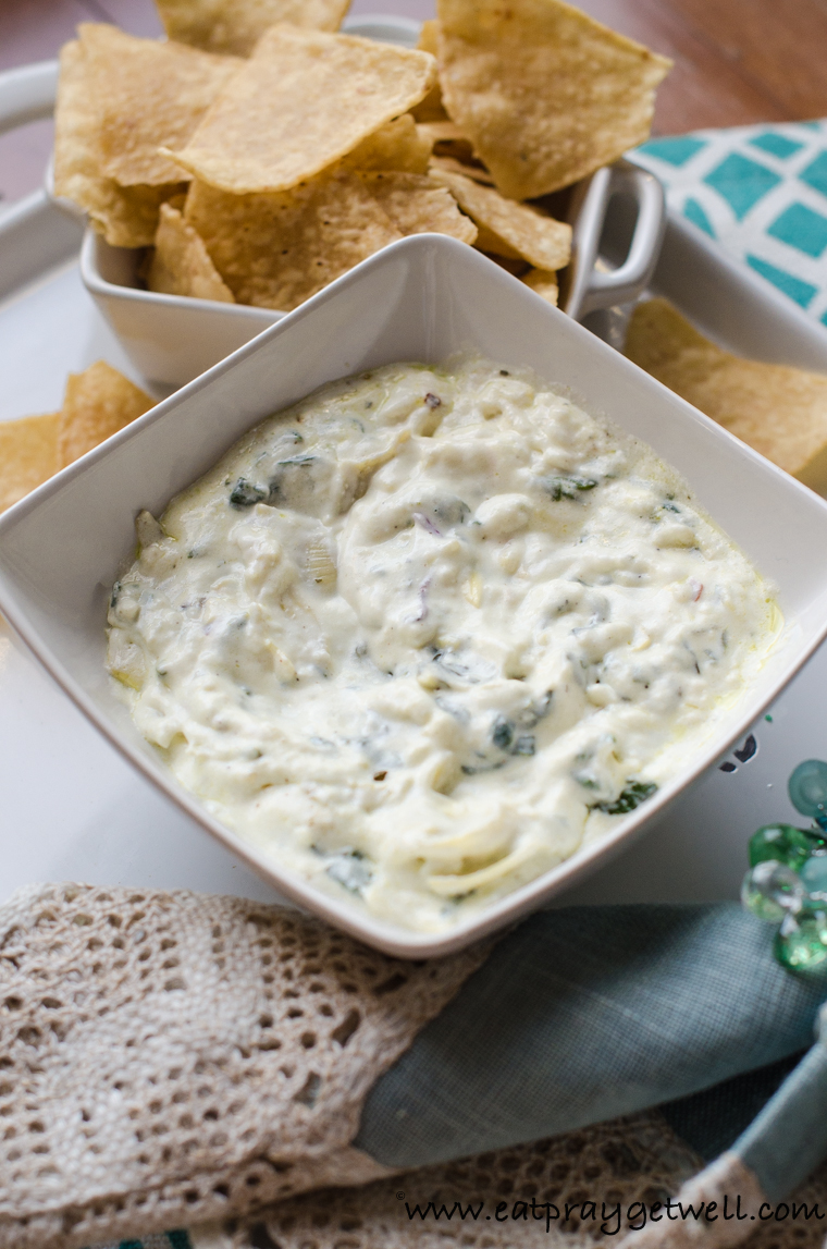 A bowl of spinach artichoke dip with bean chips