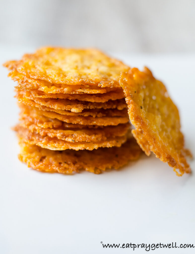 close up of cheddar parm crisps with a white back ground
