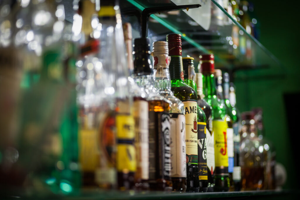 variety of alcohol bottles on a bar shelf