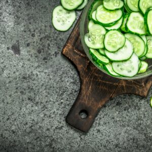 cucumber slices in a bowl on wooden cutting board